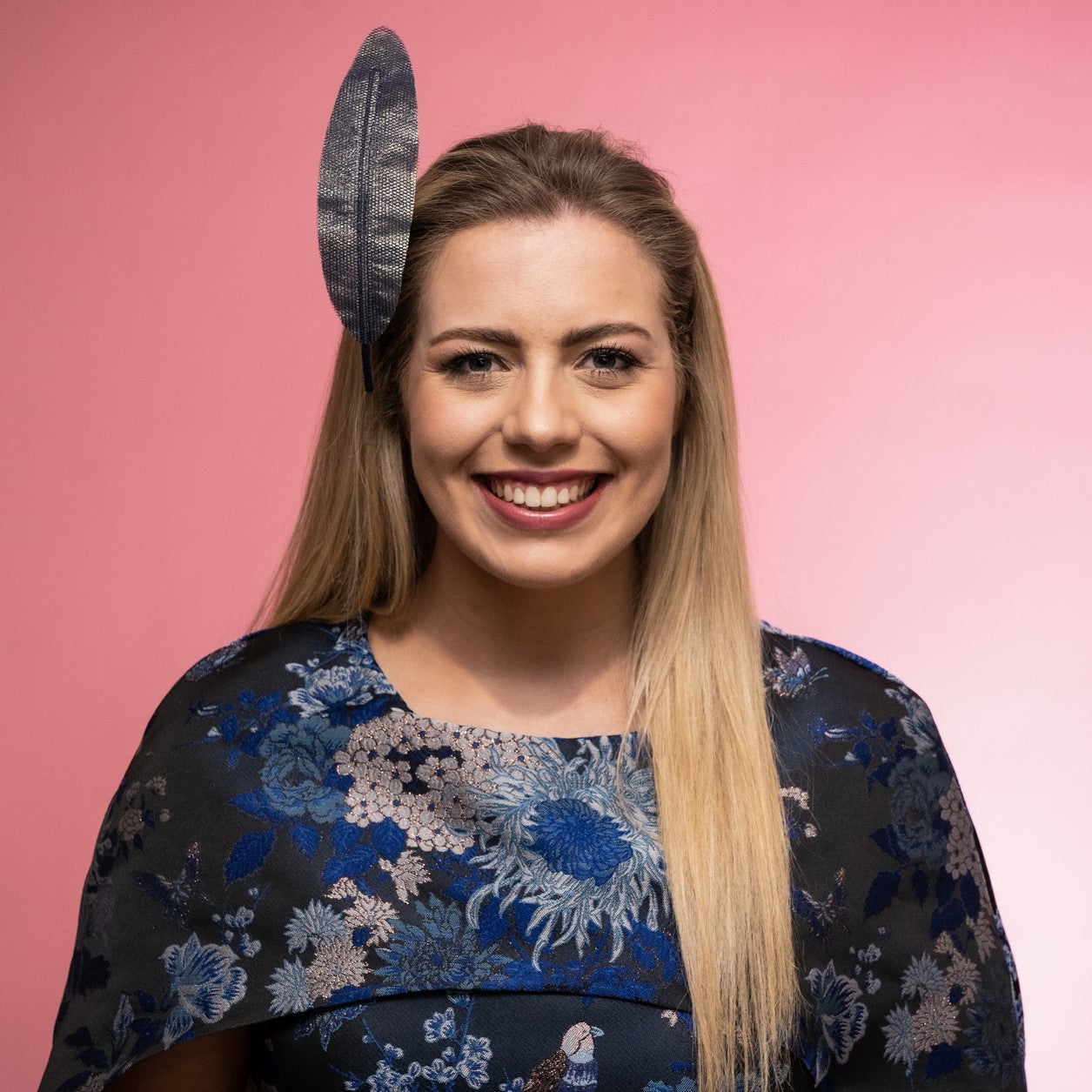 A front view of a model wearing the Alba Headband in navy, a floating tulle feather, secured to the head using a headband. Created by Melbourne based Lauren J Ritchie Millinery.