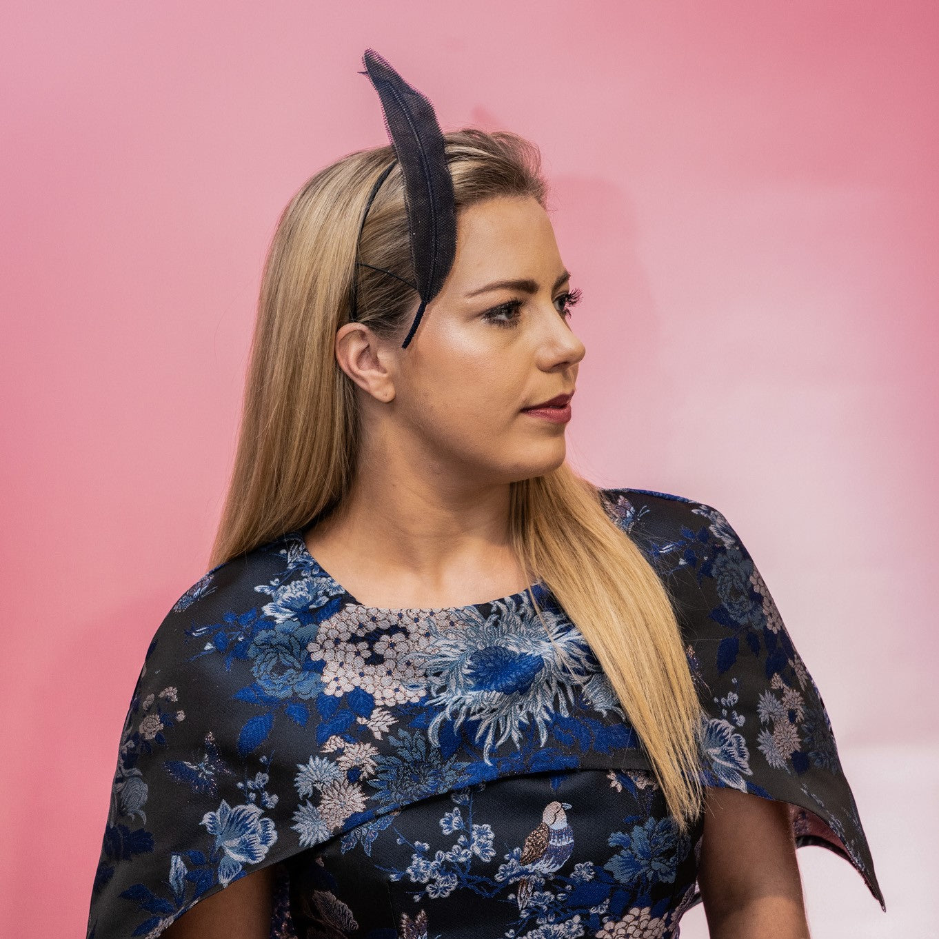 A side view of the Alba Headband in navy. This photo shows that the floating tulle feather is secured to the head using a headband. Created by Melbourne based Lauren J Ritchie Millinery.