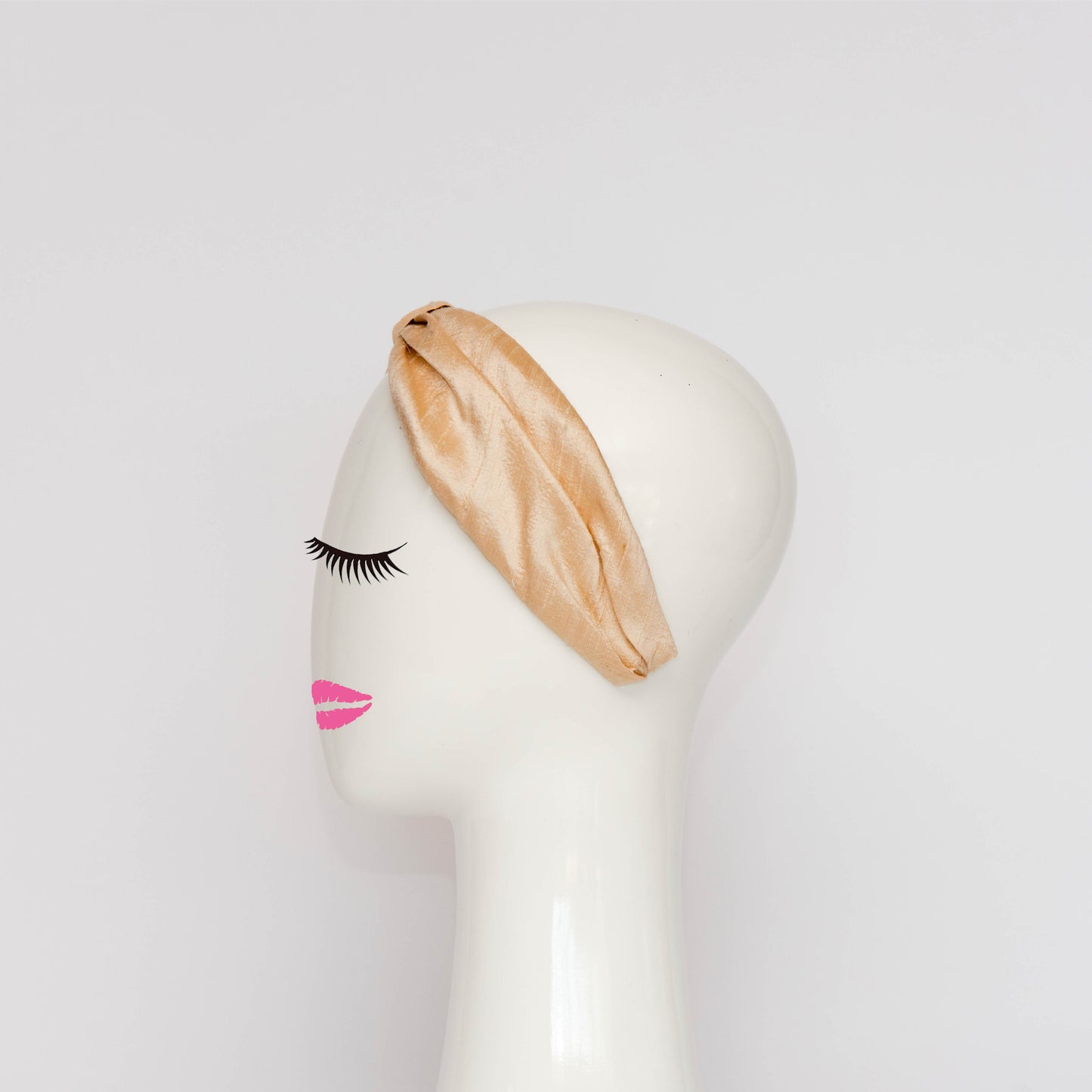 A side view of the Georgie Headband in black. The headband is a hand draped shape that is cinched with a centre wrap.  The headpiece is created by Melbourne based Lauren J Ritchie Millinery.